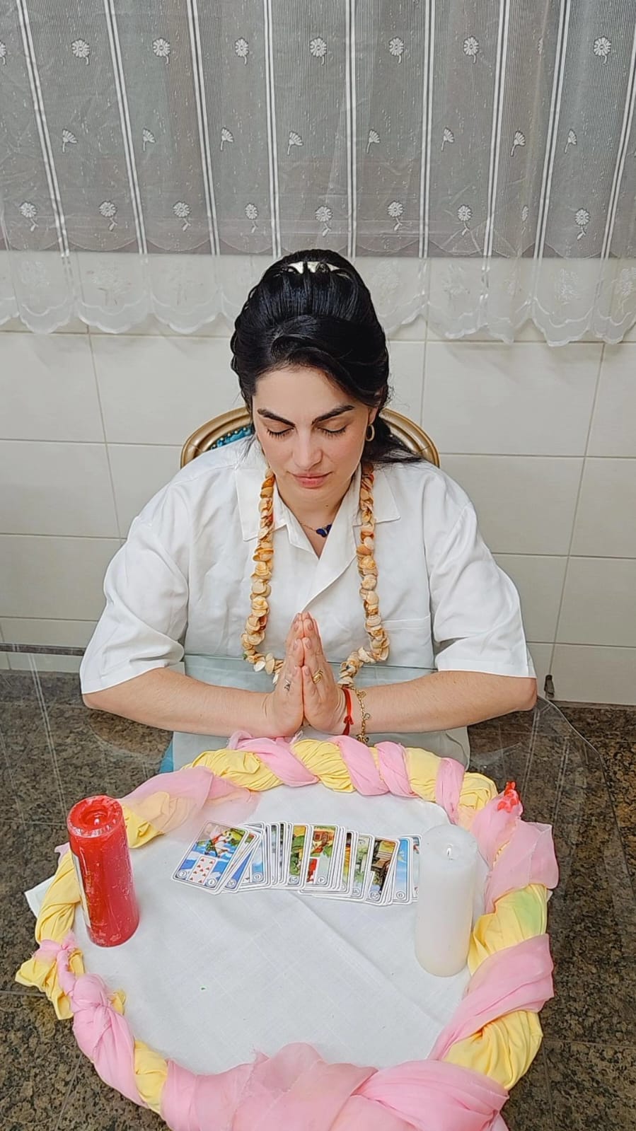 Renata em oração com cartas e velas
